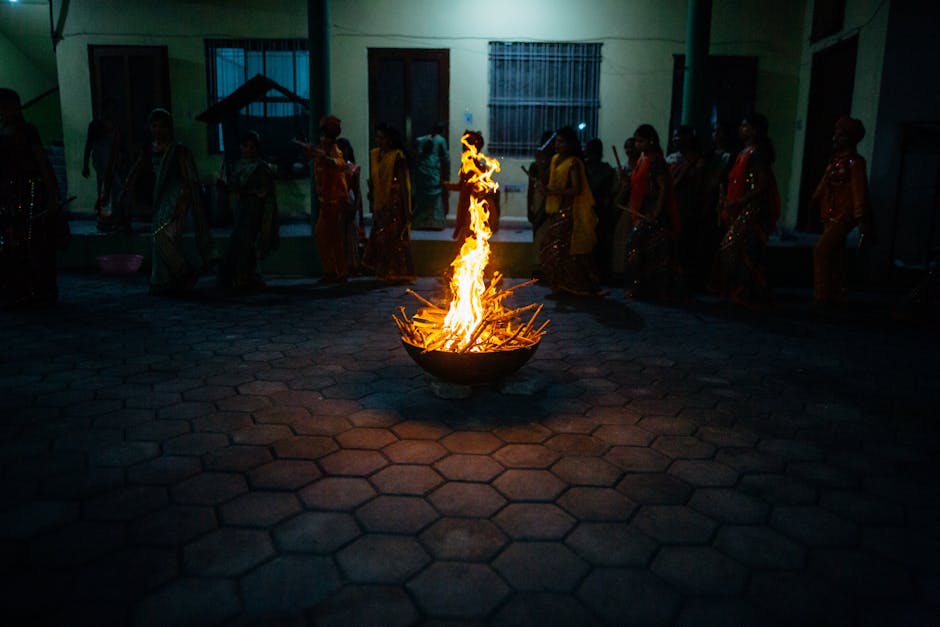 A cultural night gathering featuring a central bonfire surrounded by people in traditional attire.